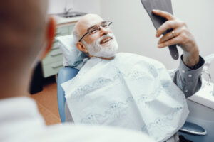 Man admiring his new smile at the dentist office